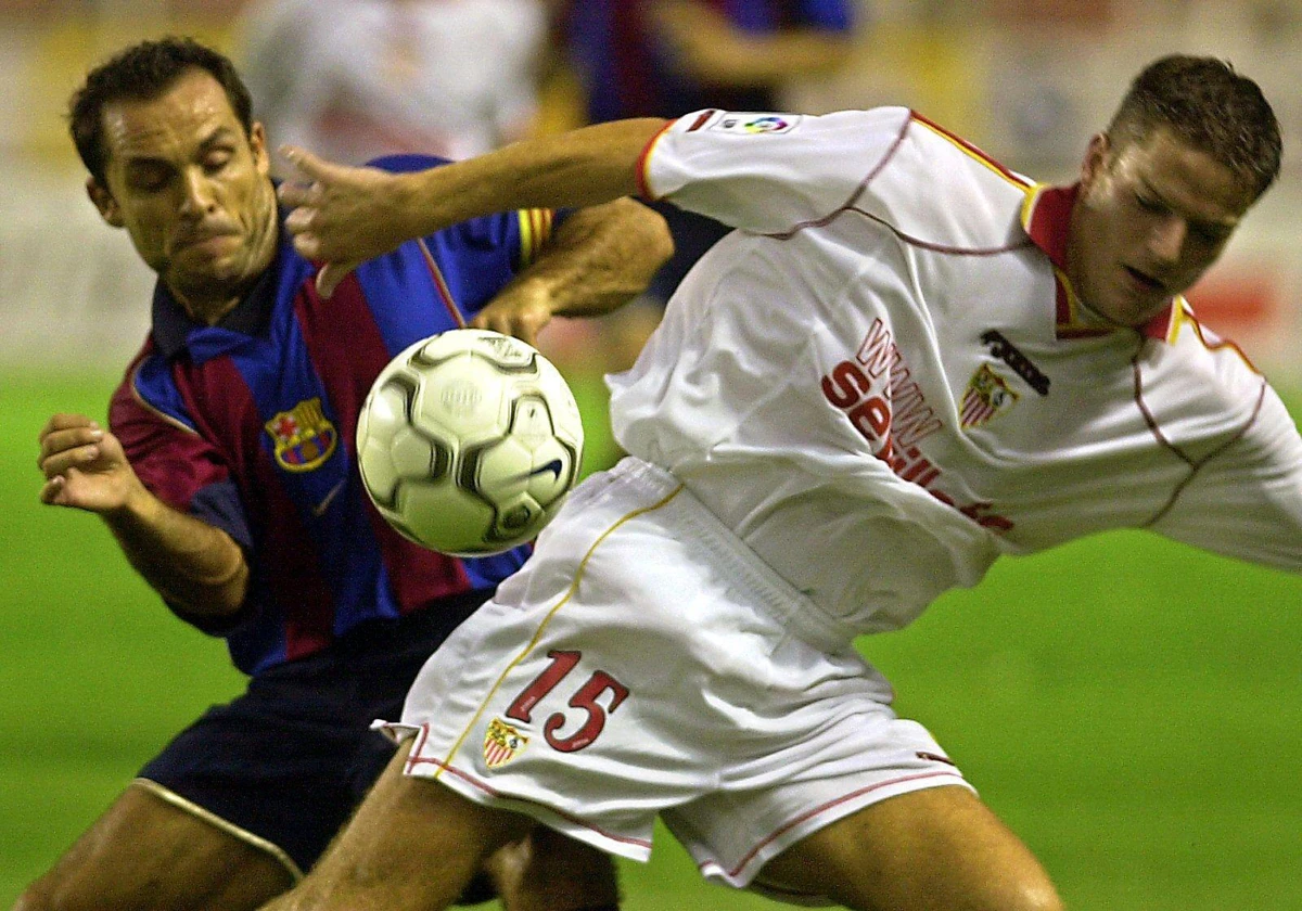 Luis Gil pelea por un balón con Sergi Barjuán en un Sevilla - Barcelona en el año 2001