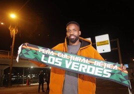 Bakambu posa con una bufanda el día de su llegada a Sevilla para firmar por el Betis