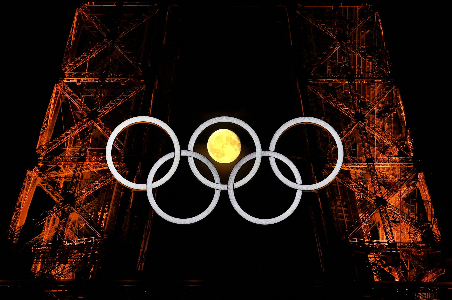 La luna a través de los anillos olímpicos en la Torre Eiffel antes de los Juegos Olímpicos de París 2024.