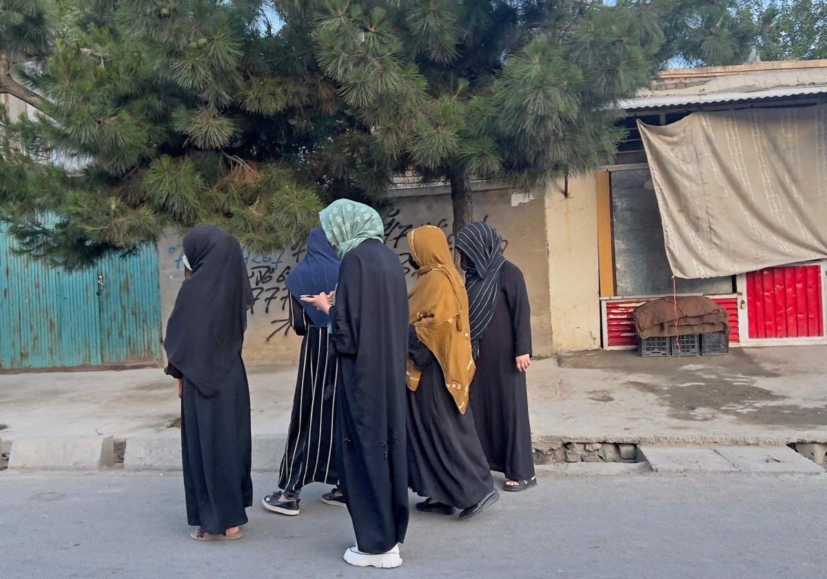 Mujeres afganas intentan hacer ejercicio caminando por una calle de Kabul