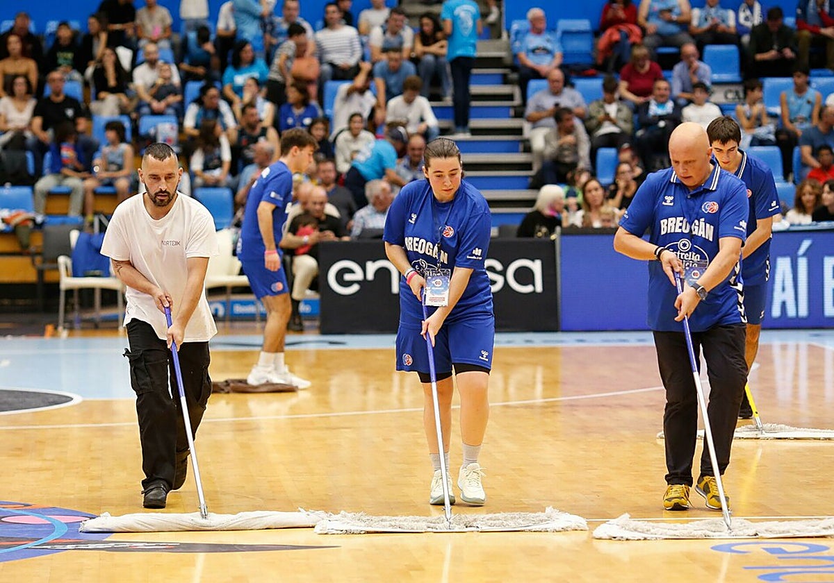 Varios trabajadores intentan secar la pista del Palacio Provincial de Deportes de Lugo
