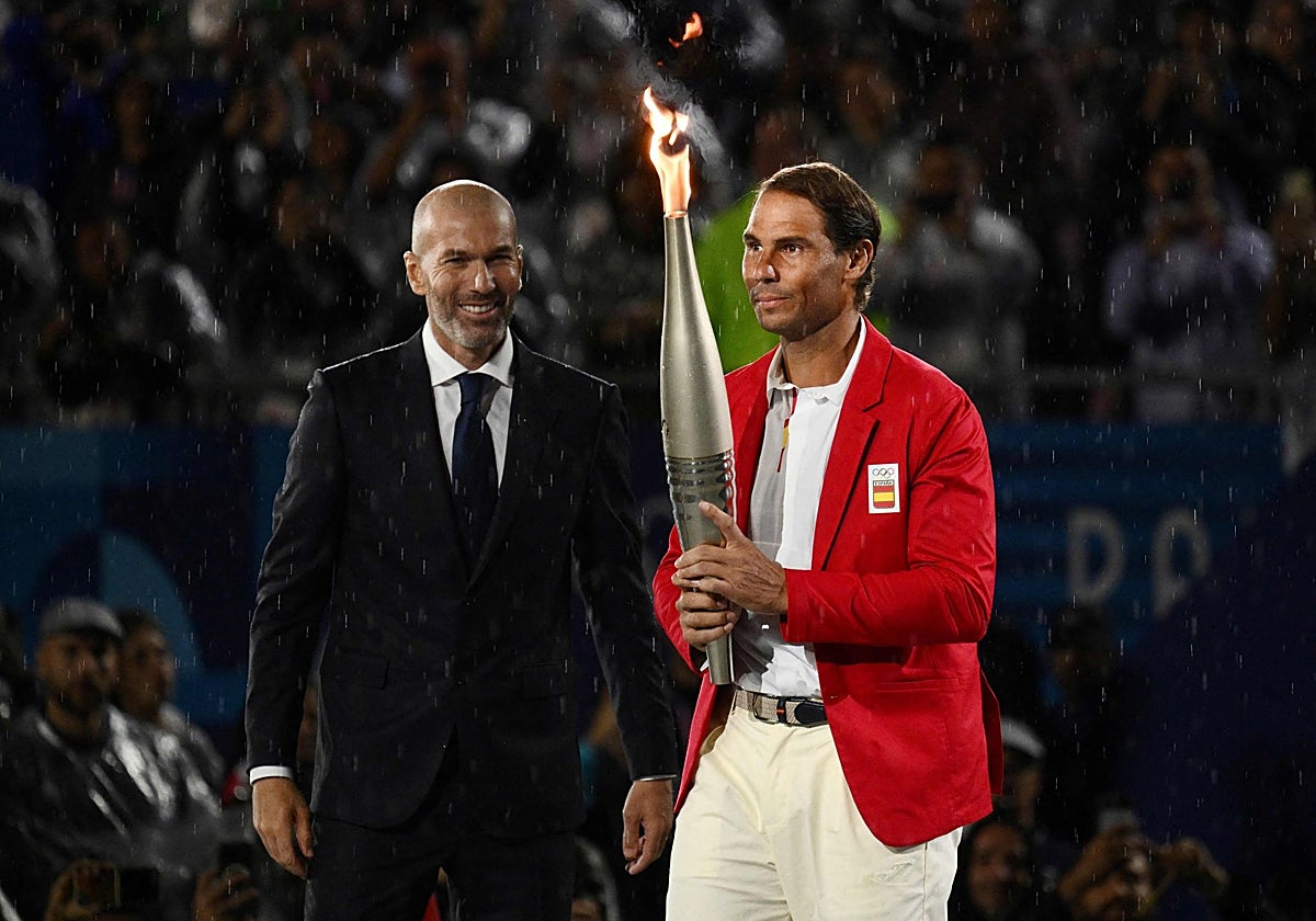 Rafa Nadal recibe de Zinedine Zidane la antorcha olímpica en la inauguración de los Juegos de París 2024