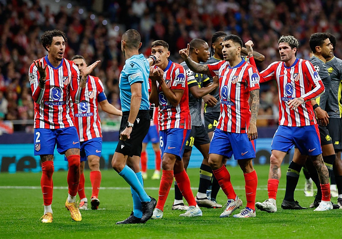 Los futbolistas del Atlético protestan a Marco Guida el penalti señalado por el italiano