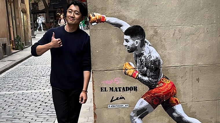 Un turista asiático, junto al mural de Topuria