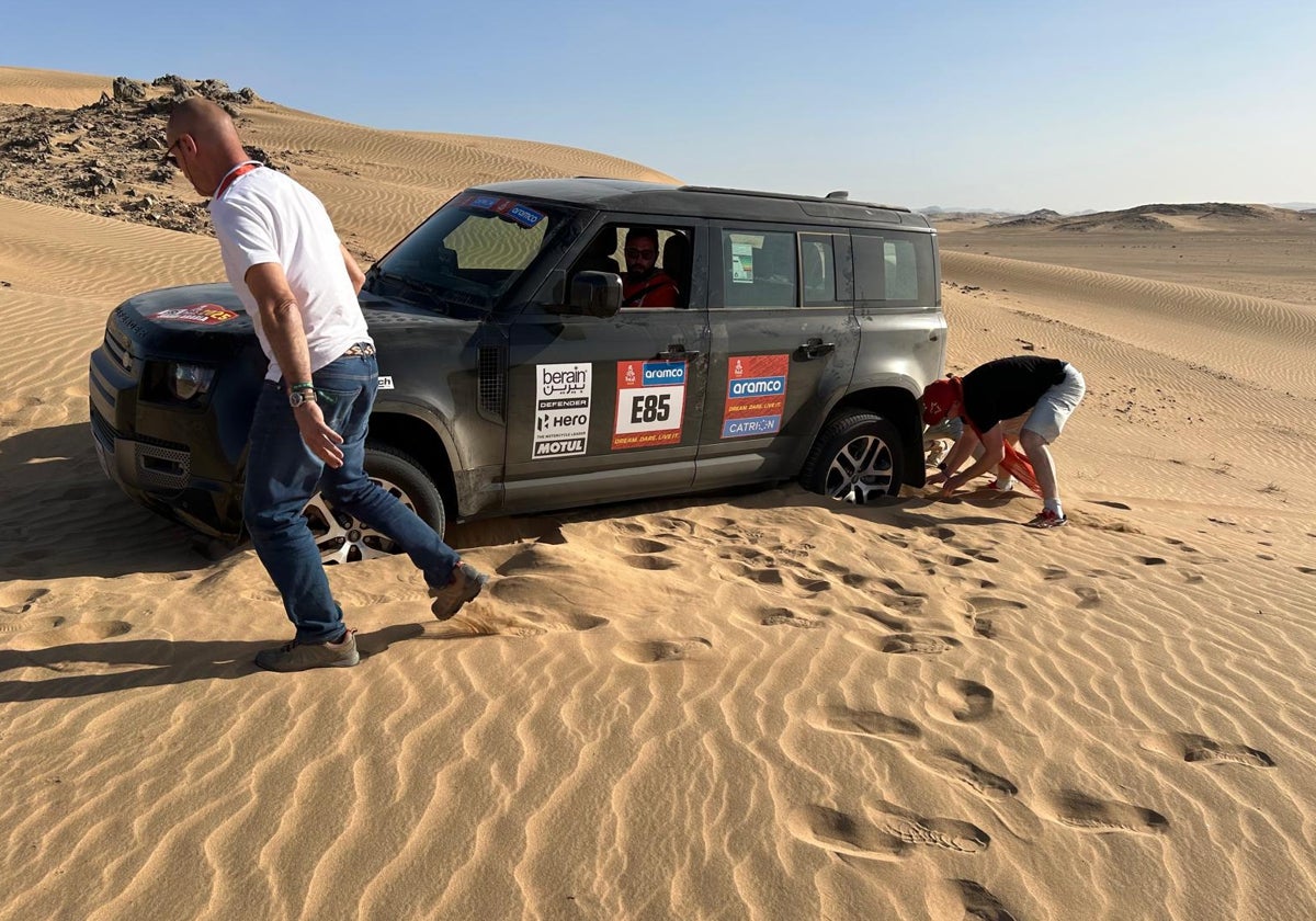 El equipo de Dacia trata de desenterrar el coche de una duna en la que quedó varado