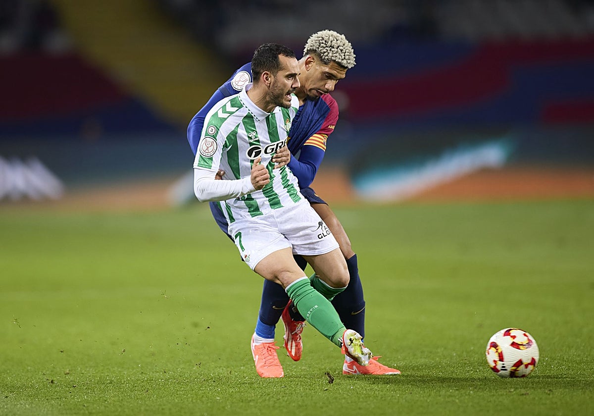 Juanmi pugna con Araujo durante el Barcelona - Betis