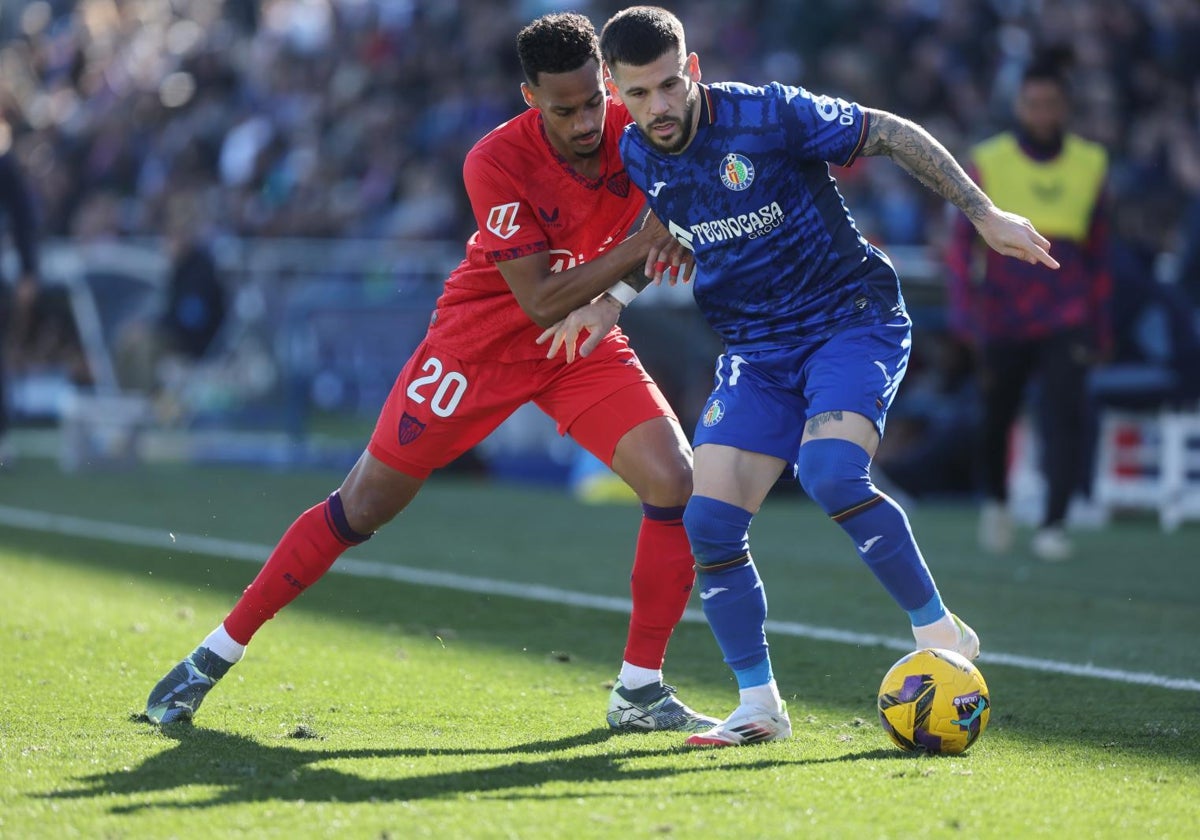 El delantero del Getafe Carles Pérez pelea por un balón ante Djibril Sow durante el partido de la jornada 22 de LaLiga EA Sports que enfrenta al Getafe contra el Sevilla