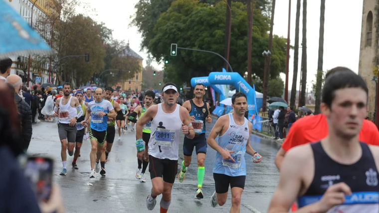 Corredores de la Media Maratón de Sevilla 2025, a su paso por el Paseo de Colón, junto a la Torre del Oro