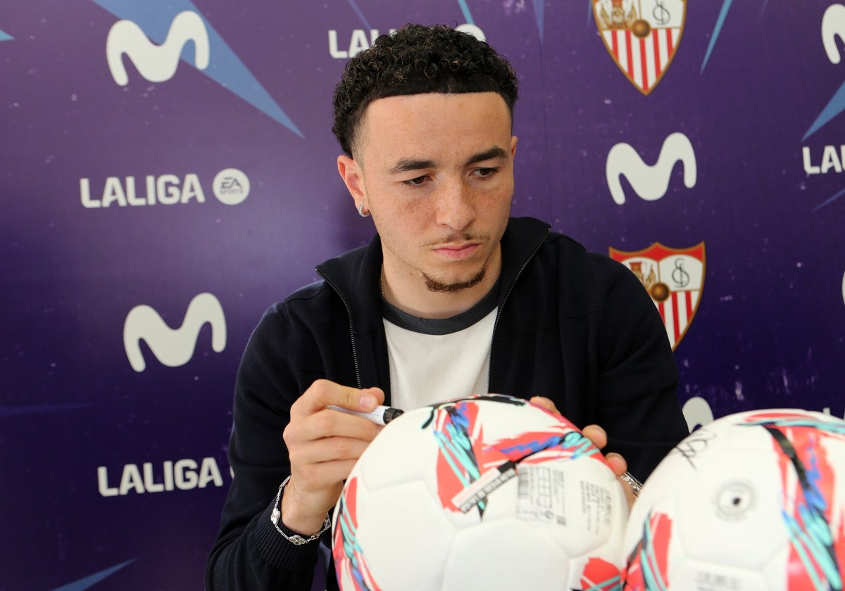 Rubén Vargas firma un balón de la Liga en un acto comercial del Sevilla