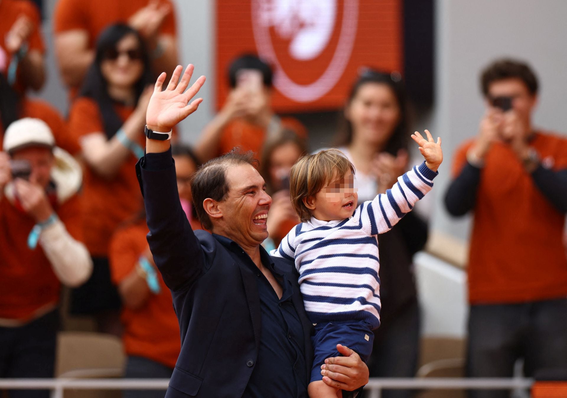 Nadal, con su hijo en brazos, saluda sonriente a la grade de la Philippe Chatrier.