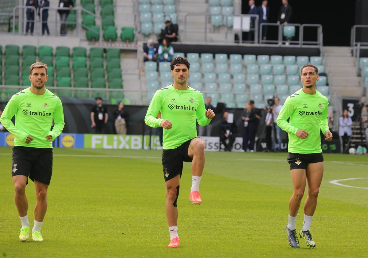 Johnny Cardoso calienta en Breslavia entre Lo Celso y Antony antes de la final de la Conference League