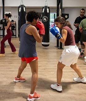 Imagen secundaria 2 - En la primera imagen, Esperanza practica golpes durante un entrenamiento; Patricia, en la segunda foto, posa a los pies del ring e Idalisa y su hija Patricia siguen la clase.