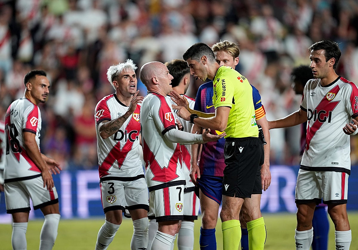 Los jugadores del Rayo protestan al árbitro del partido, Busquets Ferrer