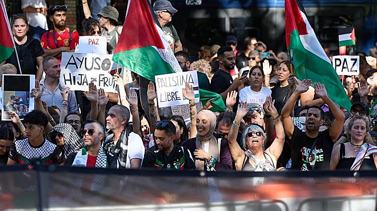 Manifestantes con pashminas, banderas de Palestina y carteles pidiendo la paz este domingo en Madrid.