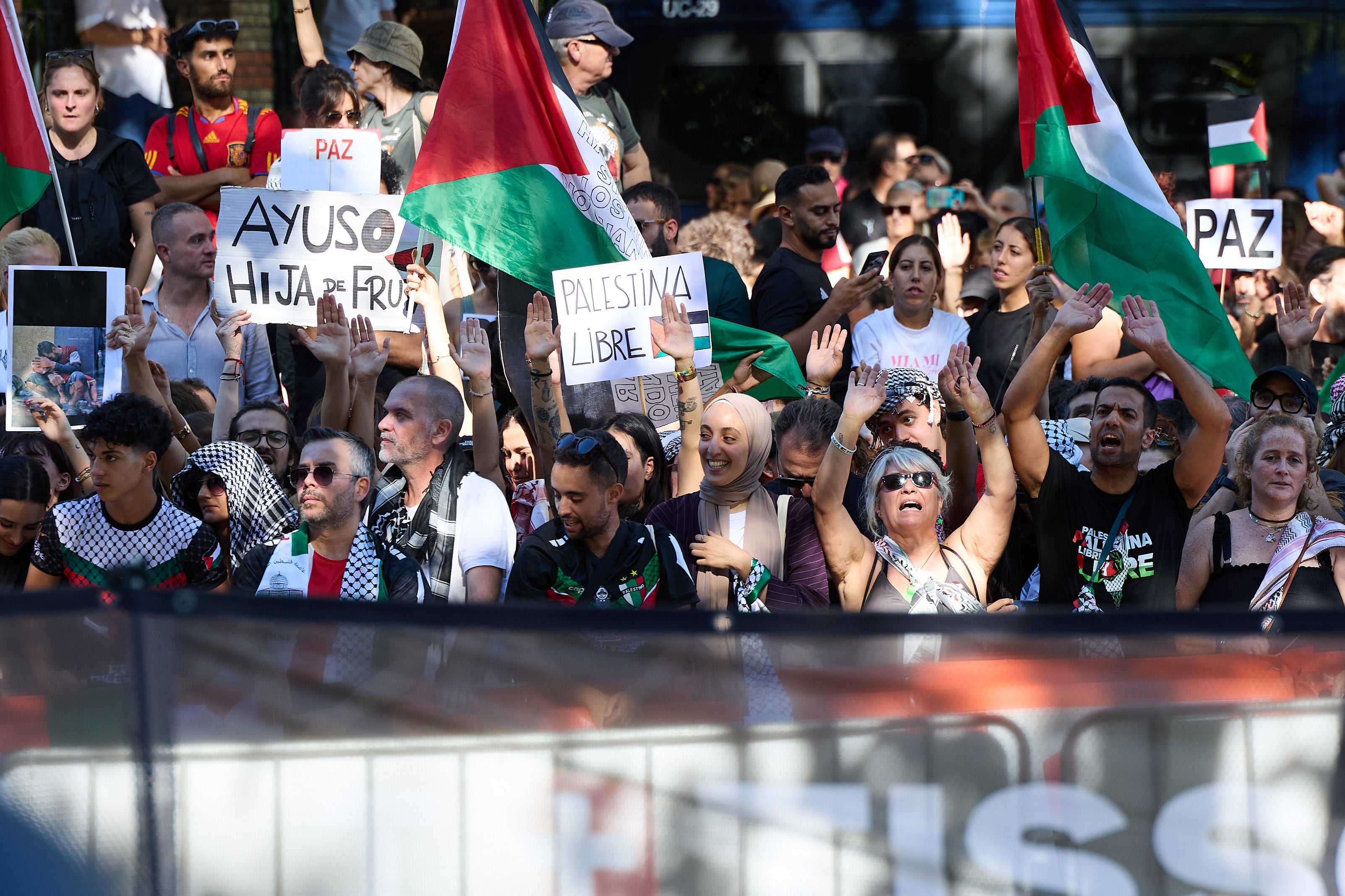 Manifestantes con pashminas, banderas de Palestina y carteles pidiendo la paz este domingo en Madrid.