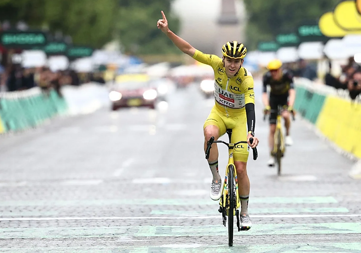 Pogacar levanta el brazo al cruzar la línea de meta de París