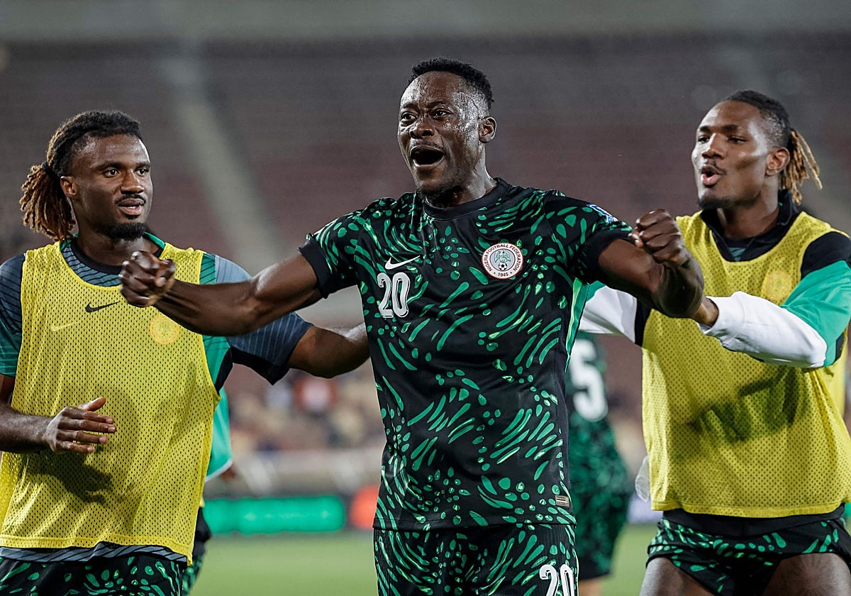 Akor Adams celebra con dos compañeros la victoria de Nigeria frente a Lesoto