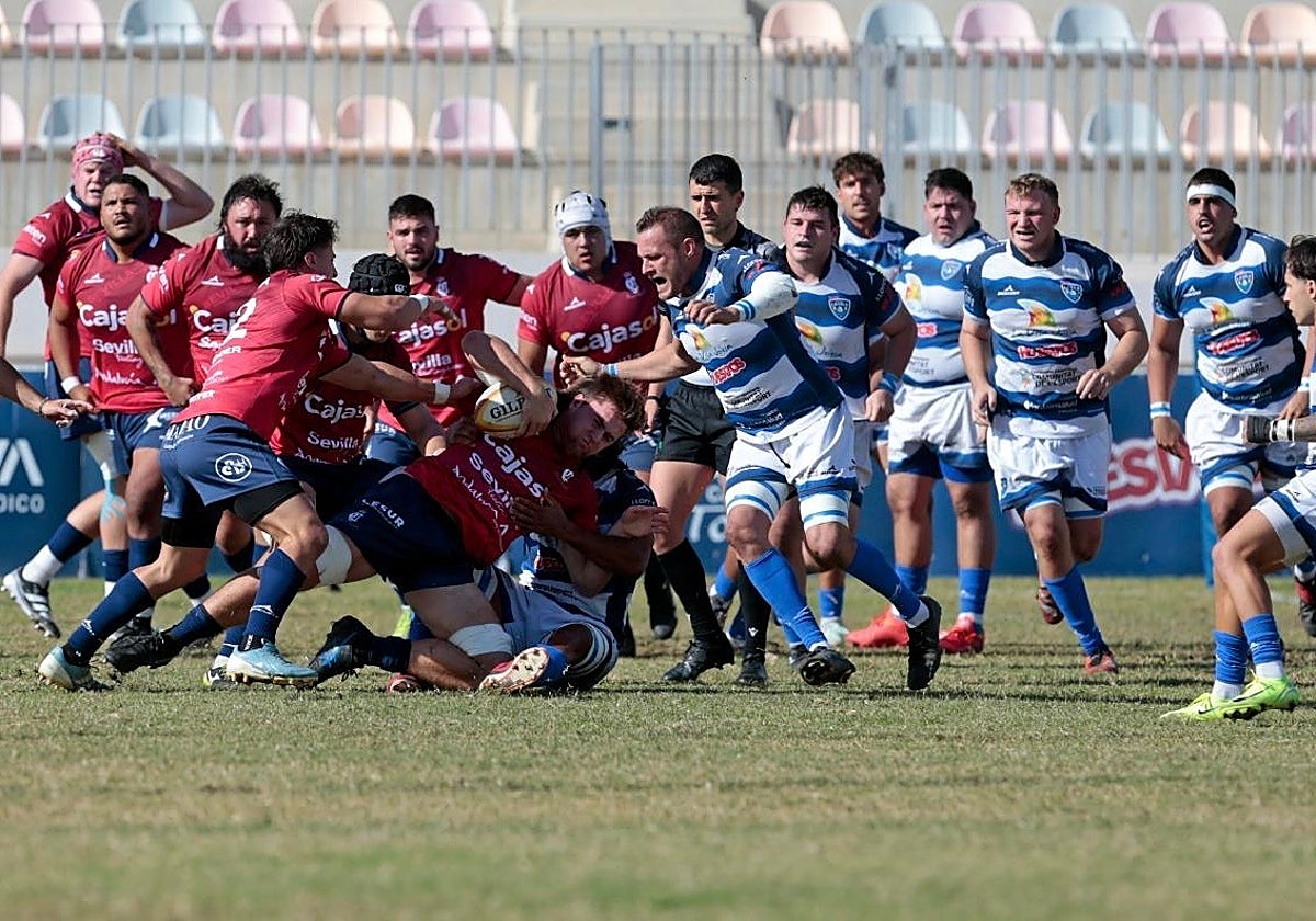 Los jugadores científicos se afanan por retener el oval ante un placaje de La Vila