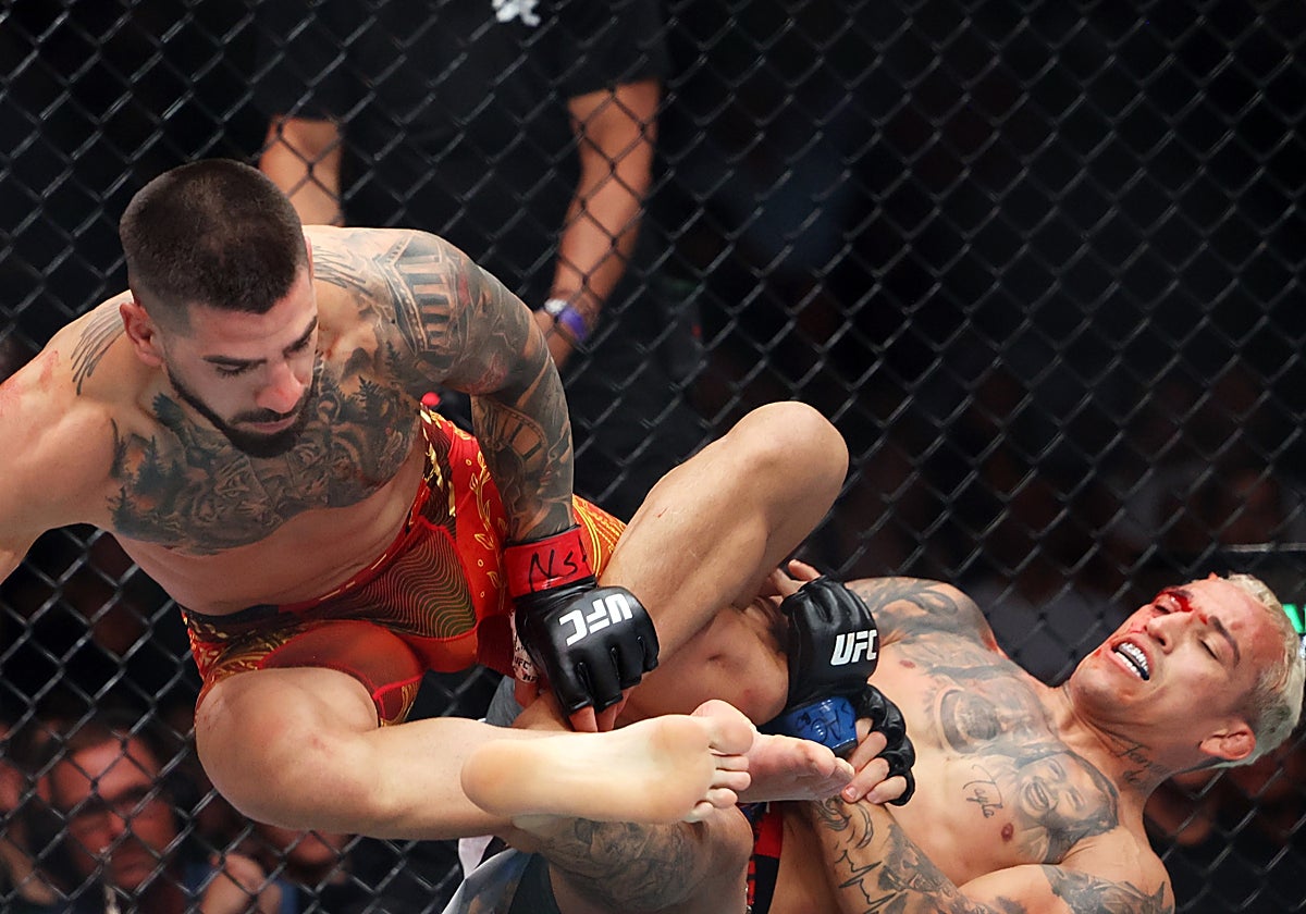 Charles Oliveira intenta ejecutar una llave sobre la pierna de Ilia Topuria