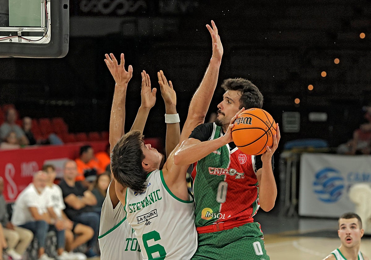 Sergio Cecilia, del Insolac Caja 87, defendido por dos jugadores del CB Toledo
