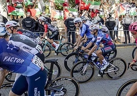 Corredores del equipo Israel Premier-Tech, delante de una manifestación propalestina