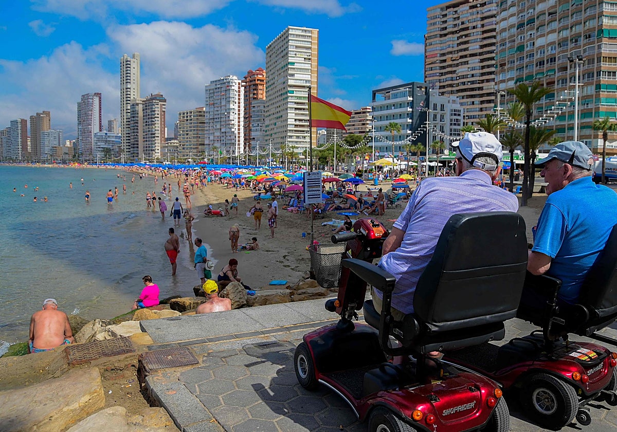 Dos ancianos miran la playa en Benidorm