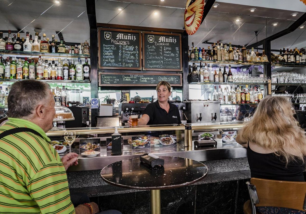 Una camarera en un bar de Madrid atiende a un cliente