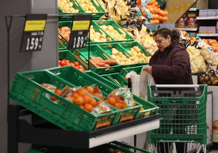 A woman buys fruits and vegetables in a supermarket