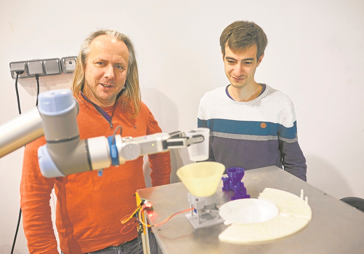 Dr. Maciej Haranczyk y Miguel Hernández junto al brazo robótico que realiza los experimentos con los compuestos
