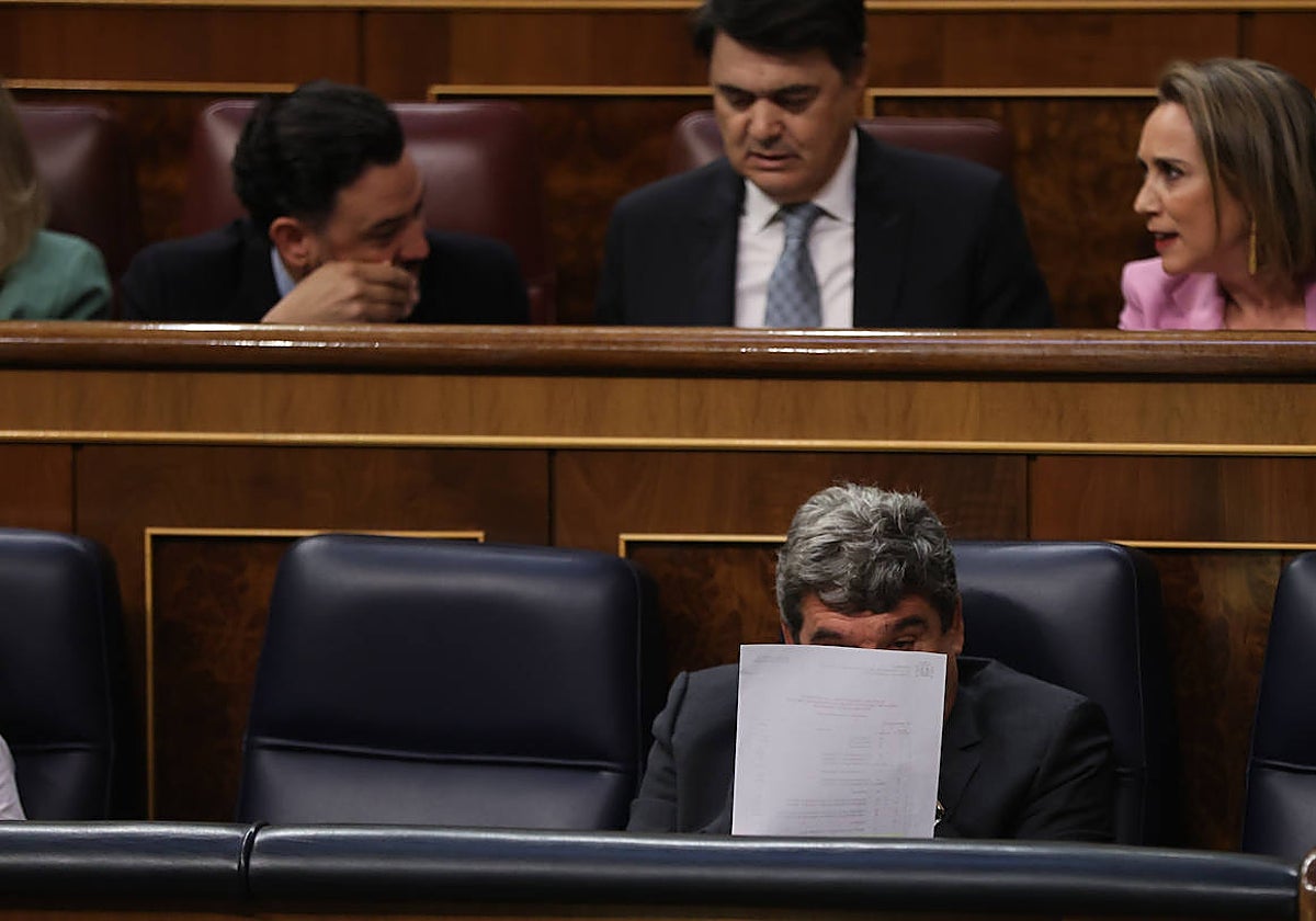 El ministro Escrivá, tras un folio, durante una sesión de control al Gobierno