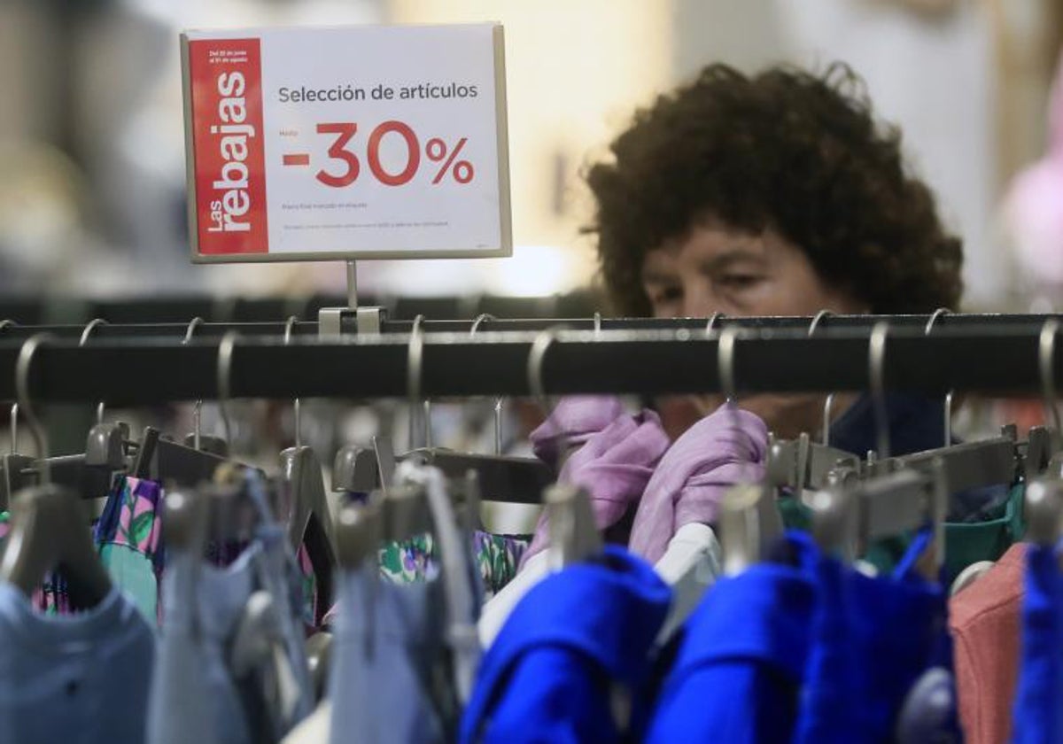 Una mujer mira ropa en un comercio en el primer día del periodo de rebajas, en Madrid