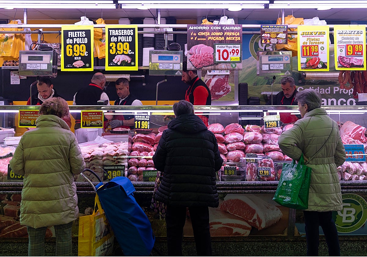 Varias mujeres compran en una carnicería en un mercado