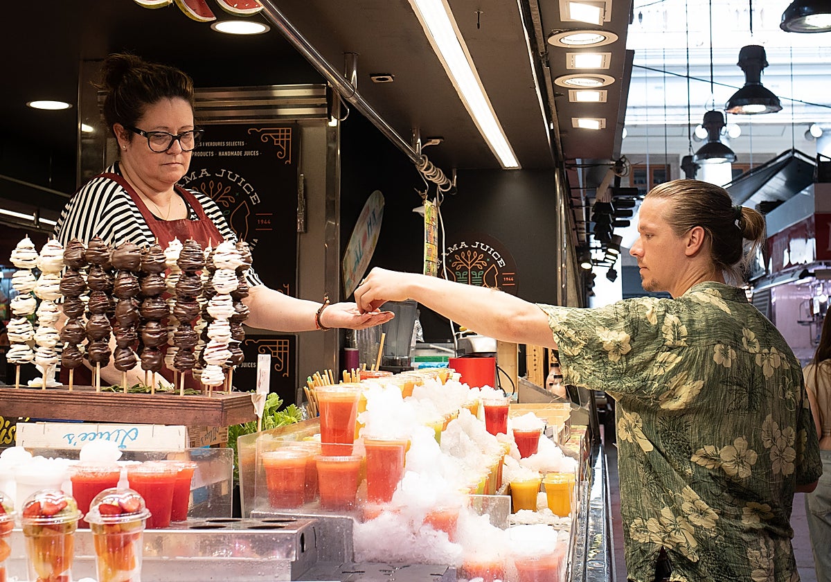 Un cliente compra en el mercado de la Boquería (Barcelona)
