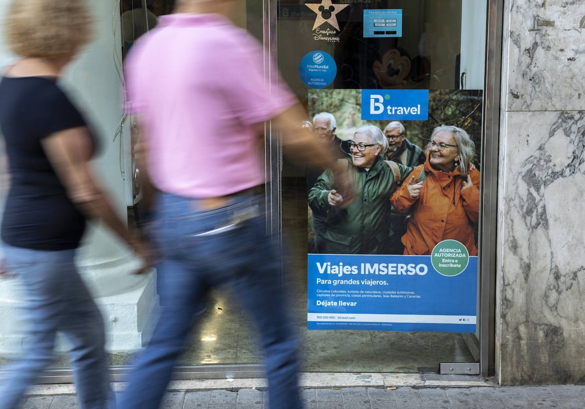 Varias personas mayores piden información en una agencia de viajes