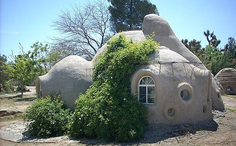Imagen principal - Arriba, una vivienda de 35m2 diseñada por el Instituto de California que ejemplifica la eficiencia energética de este tipo de construcciones. Abajo a la izquierda, una construcción de superadobe en Argentina. Este tipo de soluciones son más habituales en Iberoamérica. A la derecha, un prototipo de uno de los talleres de bioconstrucción de Calearth en España, que ofrece al alumno la oportunidad de aprender los rudimentos esta técnica