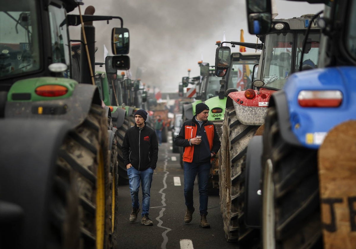 Jóvenes agricultores franceses pasan entre tractores por la autopista A4 en Jossigny, al este de París