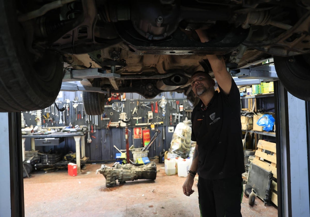 Un mecánico revisando un coche en un taller