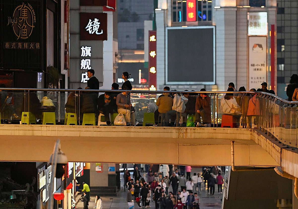 Varias personas esperan para entrar en un restaurante en el noveno día del Año Nuevo Lunar en Sichuan, China