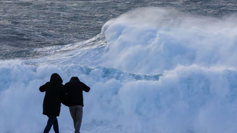 Dos turistas observan el oleaje en Muxía (La Coruña)