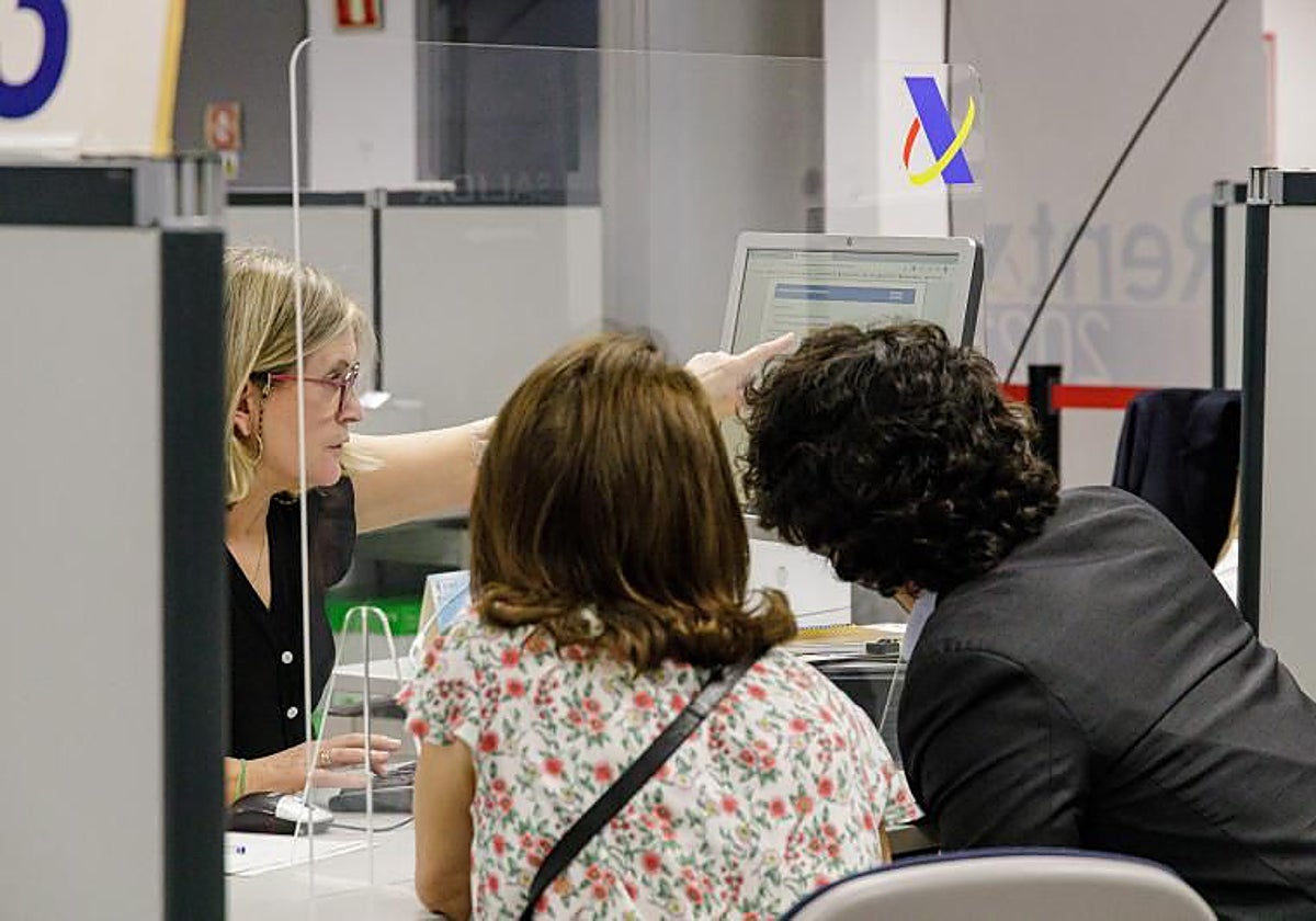 Unos contribuyentes son atendidos en una oficina de la Agencia Tributaria en Madrid