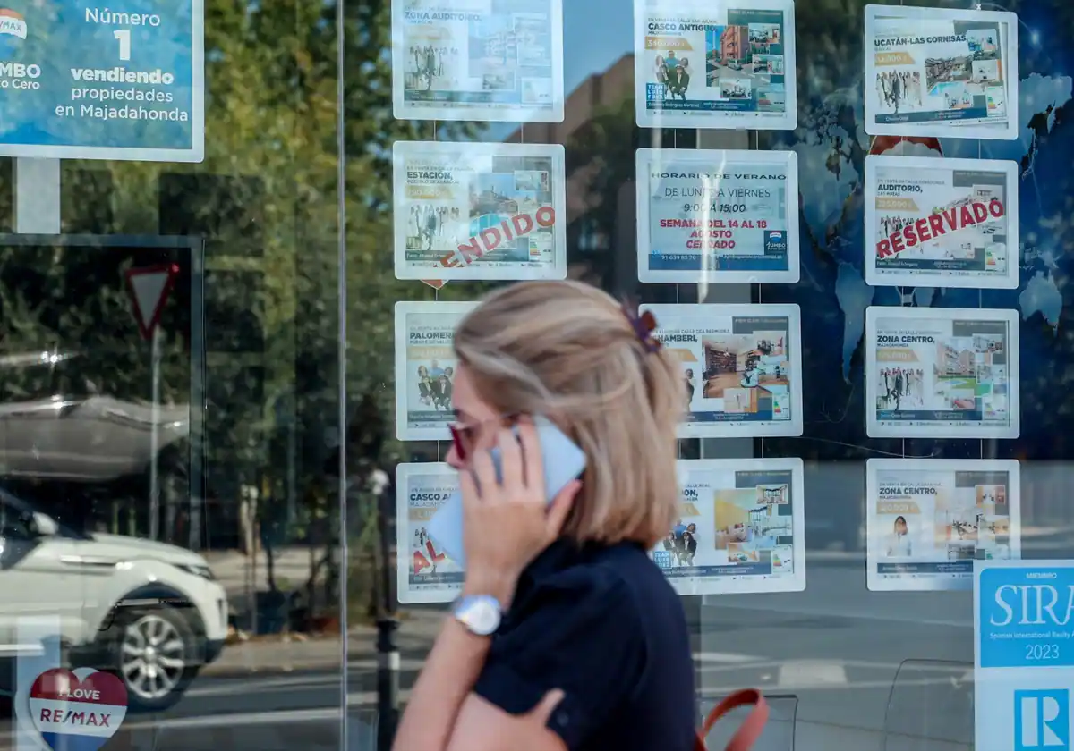 Imagen de archivo de una mujer mirando las propiedades en venta de una inmobiliaria