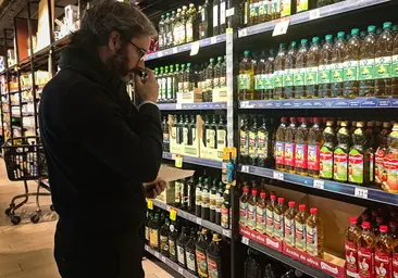 Un cliente compra aceite en un supermercado