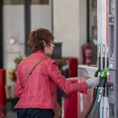 Una mujer reposta en una gasolinera