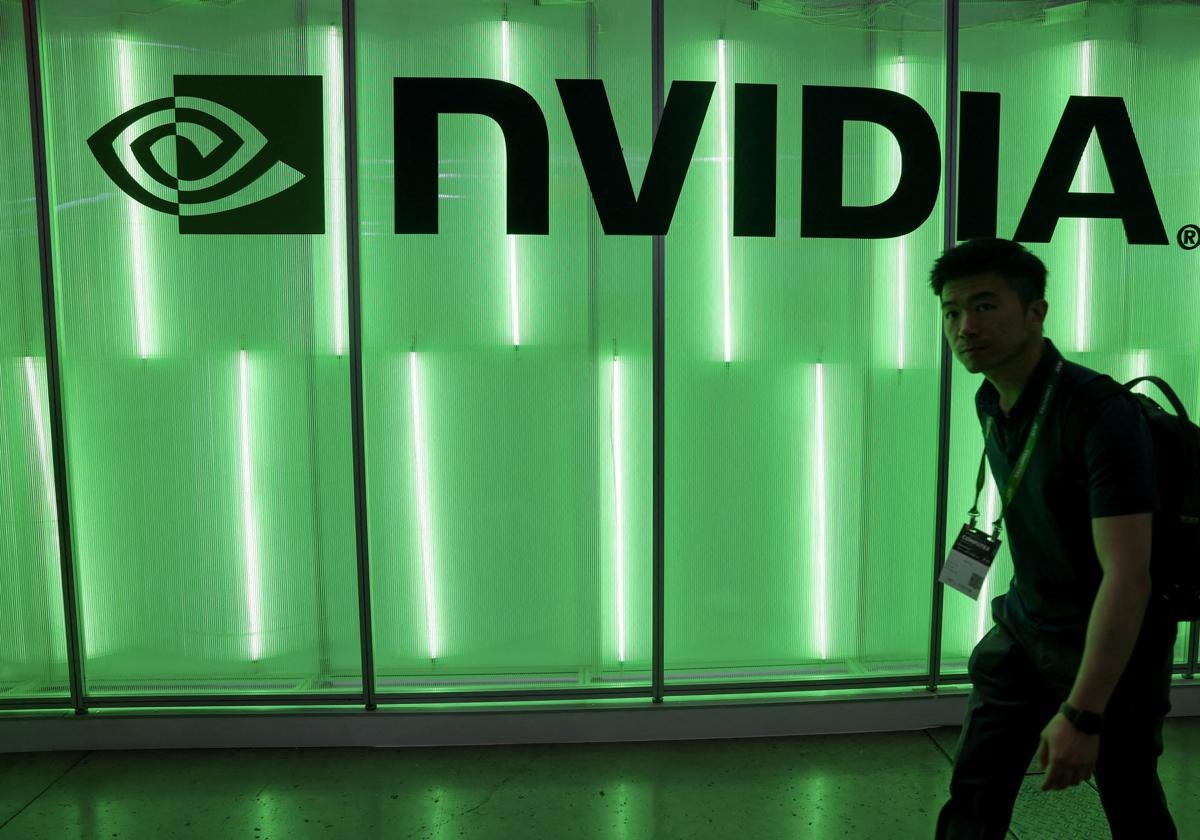 Una persona camina junto al logo de Nvidia.