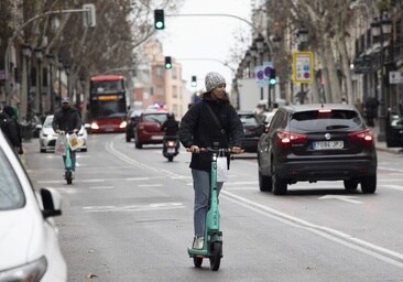 Una mujer circulando con un patinete en Madrid