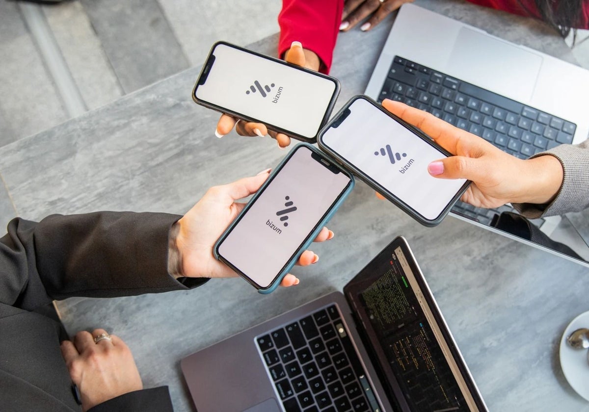 Varios jóvenes utilizando Bizum en sus teléfonos móviles