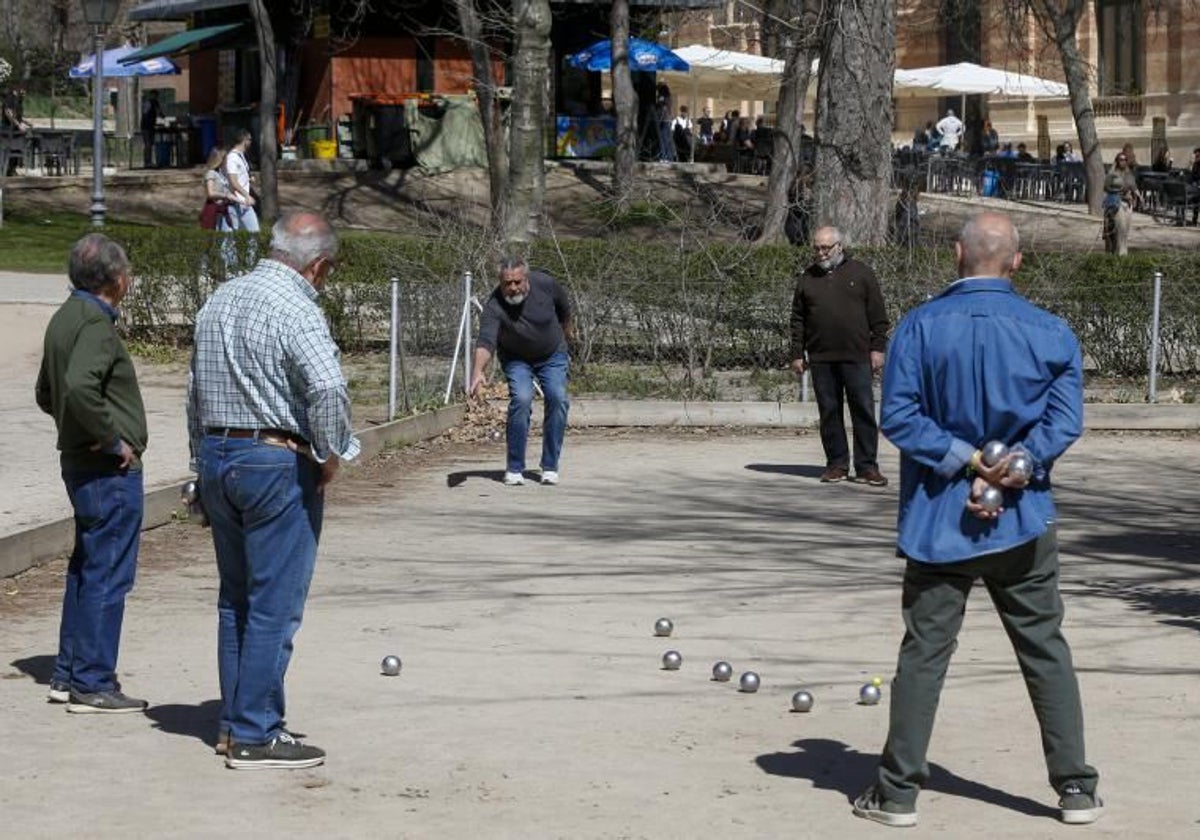 Un grupo de jubilados juega a la petanca en el Retiro, en Madrid