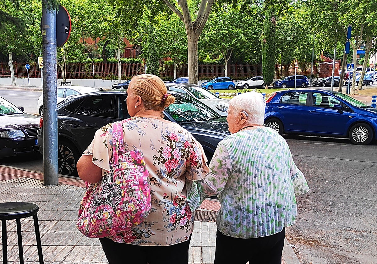 Dos viandantes pasean por la calle en Fuenlabrada (Madrid)