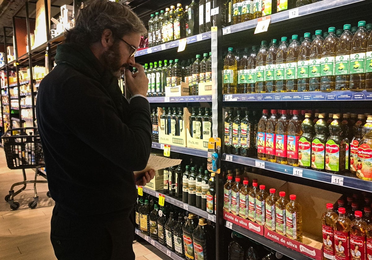 Una persona observa botellas de aceite en un supermercado