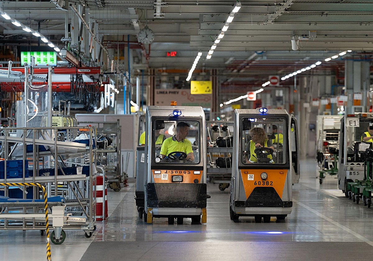 Dos empleados conducen carretillas elevadoras en una fábrica